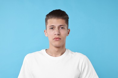 Portrait of handsome young man on light blue background