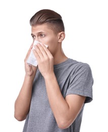 Young man with tissue suffering from sinusitis on white background