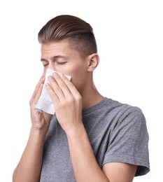 Young man with tissue suffering from sinusitis on white background