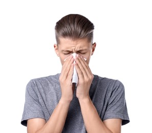 Young man with tissue suffering from sinusitis on white background