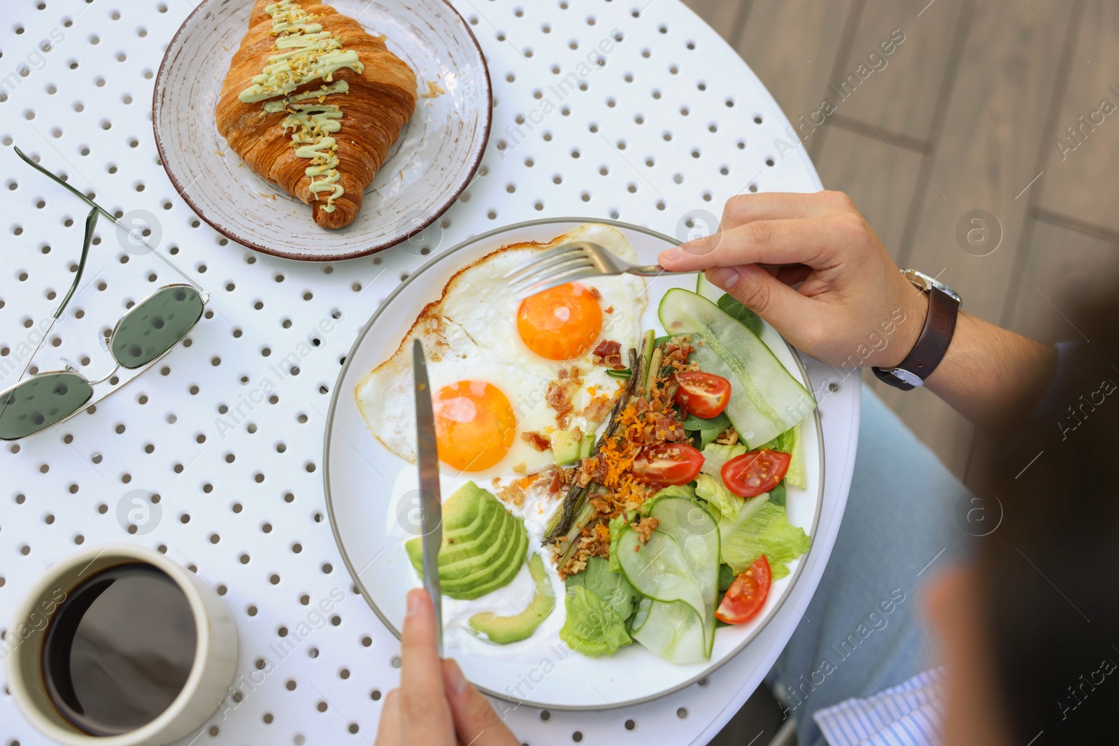 Photo of Man having tasty breakfast in outdoor cafe, top view