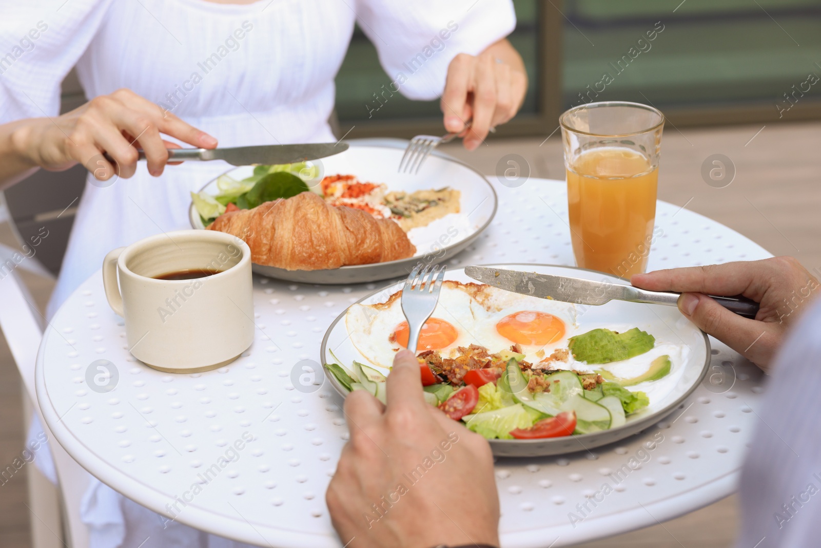 Photo of Couple having tasty breakfast in outdoor cafe, closeup