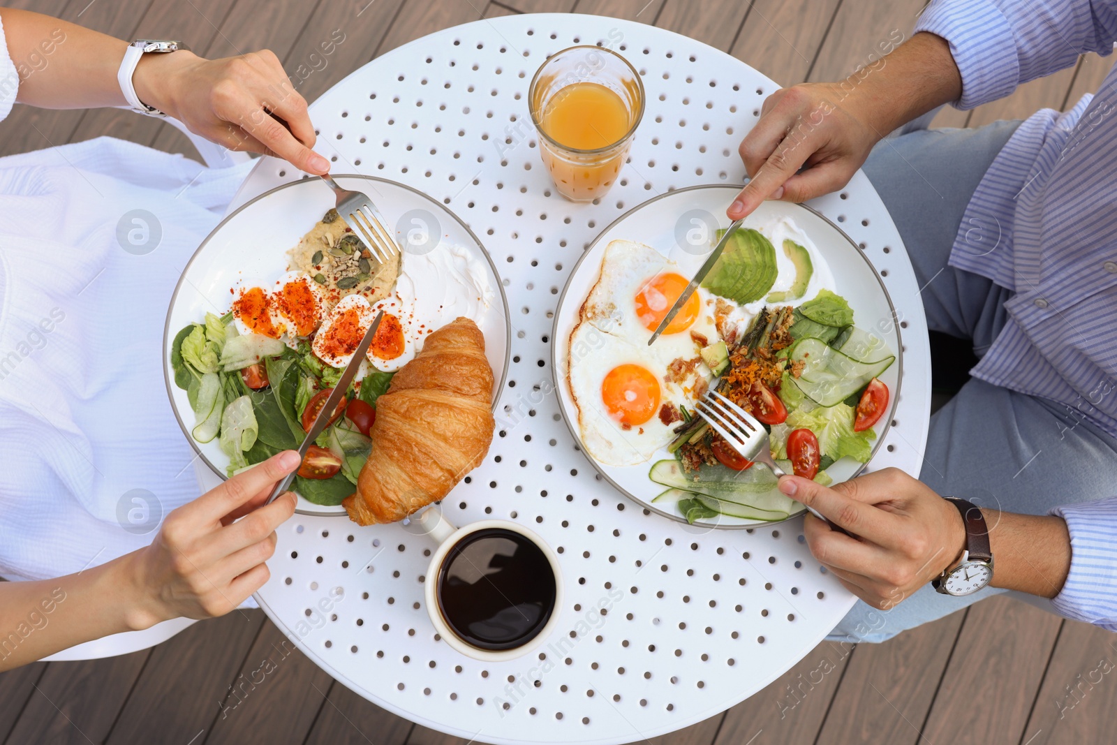 Photo of Couple having tasty breakfast in outdoor cafe, top view