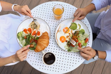 Photo of Couple having tasty breakfast in outdoor cafe, top view