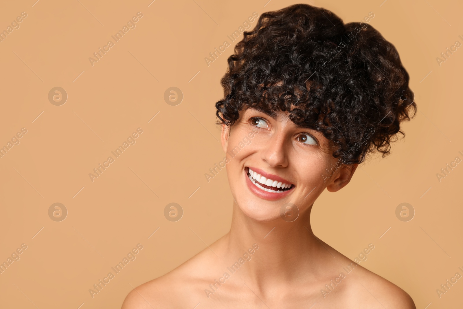 Photo of Happy young woman on beige background, space for text. Dental veneers