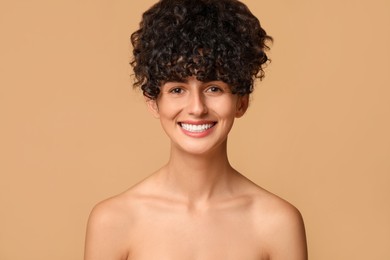 Photo of Happy young woman on beige background. Dental veneers