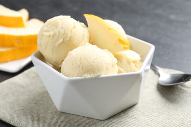 Photo of Scoops of tasty melon sorbet with fresh fruit in bowl on grey table, closeup