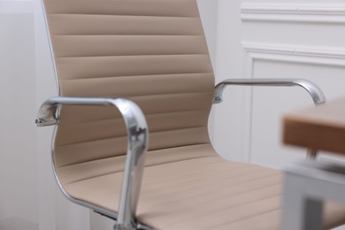 Beige leather chair and desk in office, closeup