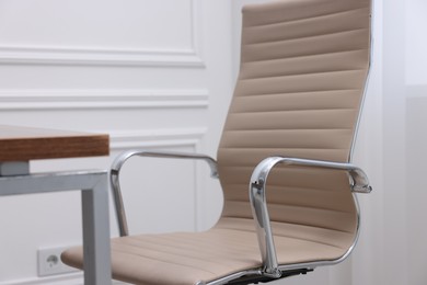 Photo of Beige leather chair and desk in office