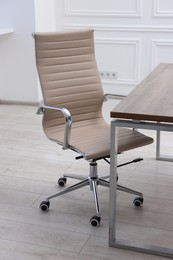 Beige leather chair and desk in office