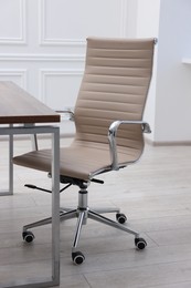 Beige leather chair and desk in office