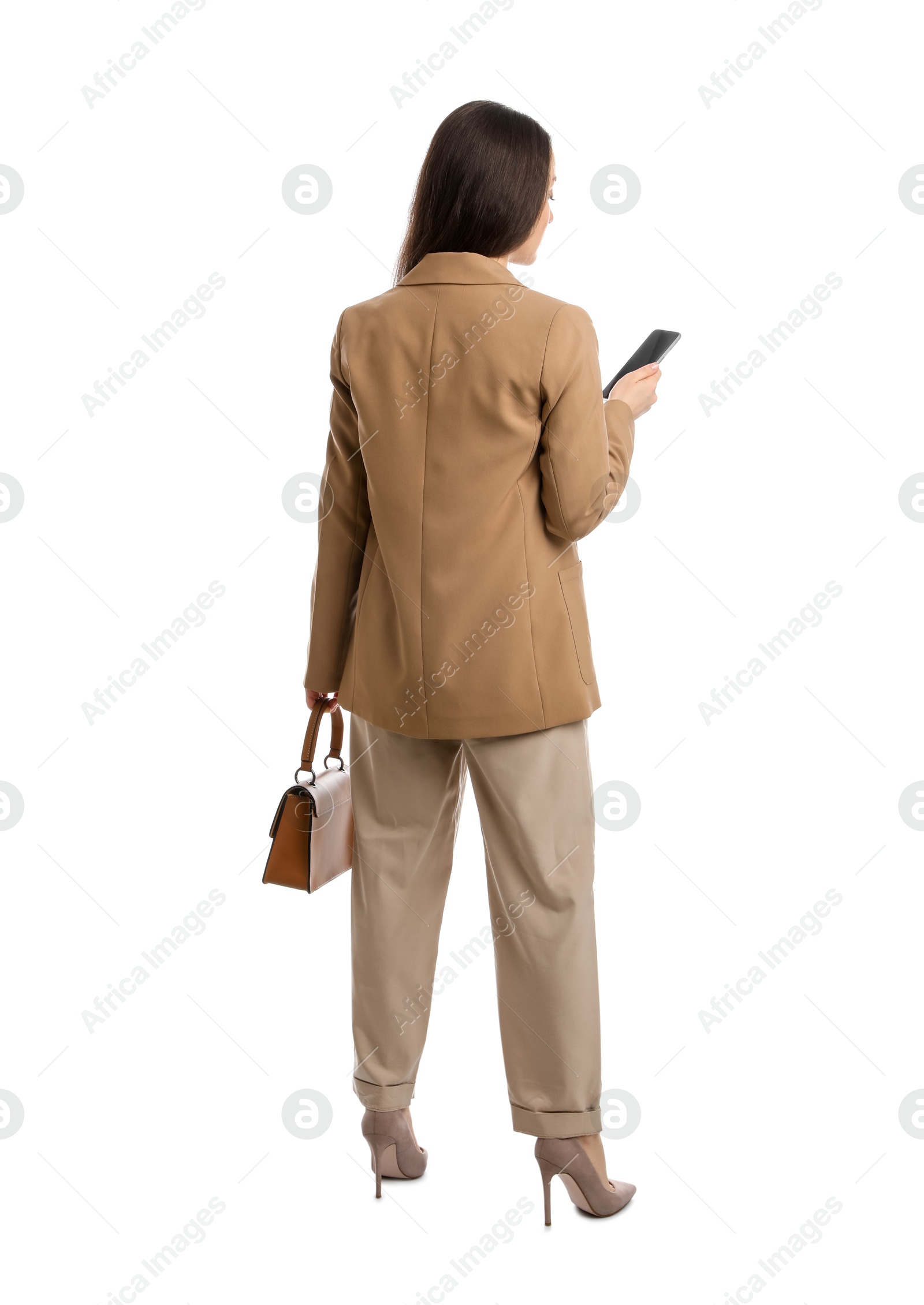 Photo of Young woman in business attire with bag and mobile phone on white background, back view