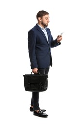 Young man in business attire with bag and mobile phone on white background