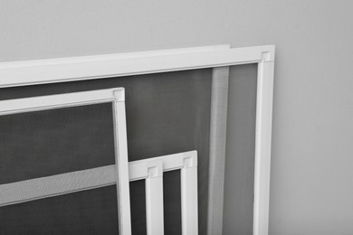 Photo of Set of window screens on light grey background, closeup