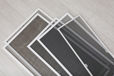 Photo of Set of window screens on wooden floor, flat lay