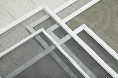 Photo of Set of window screens on wooden floor, closeup