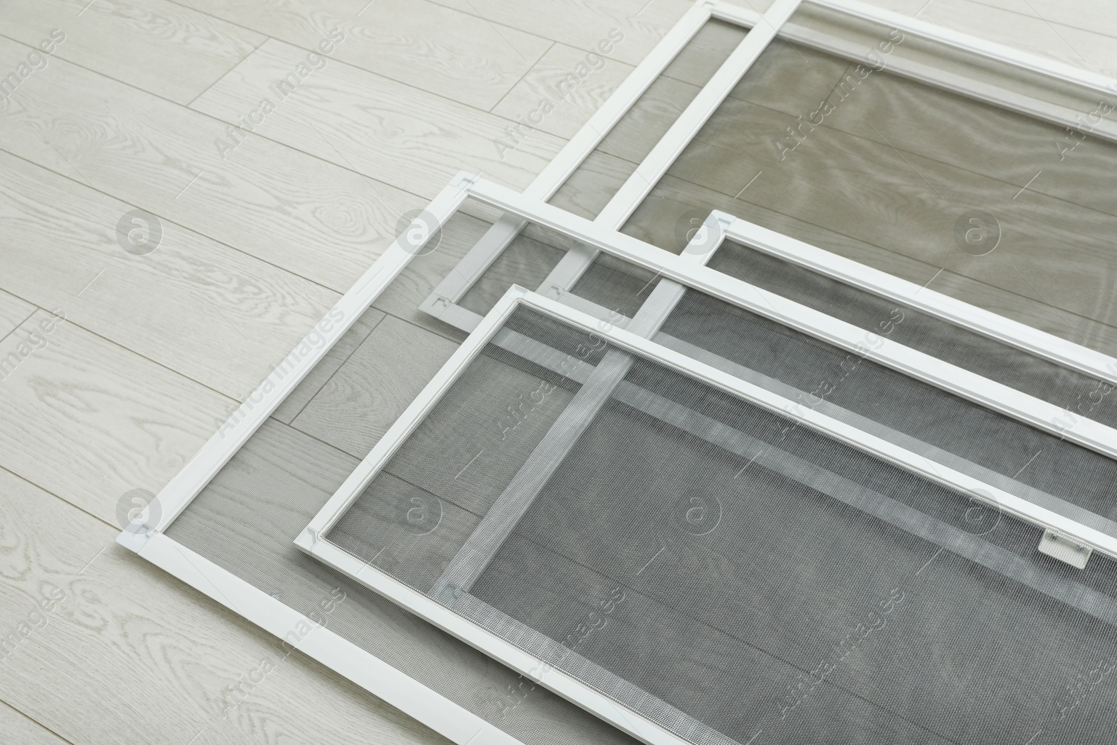 Photo of Set of window screens on wooden floor, above view