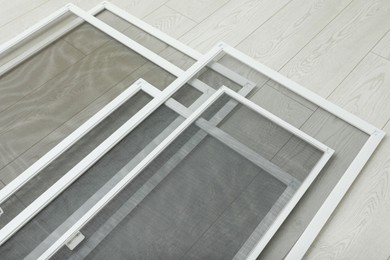 Photo of Set of window screens on wooden floor, above view