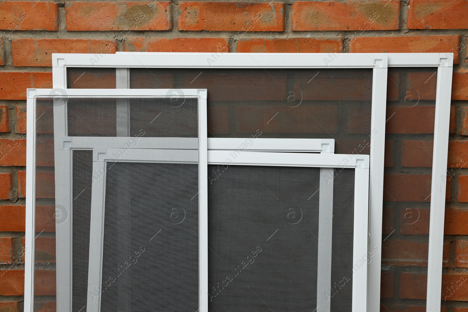 Photo of Set of window screens near brick wall