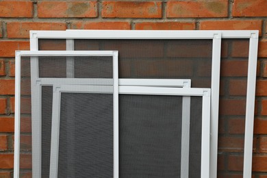 Photo of Set of window screens near brick wall