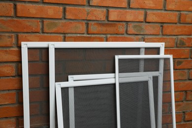 Set of window screens near brick wall