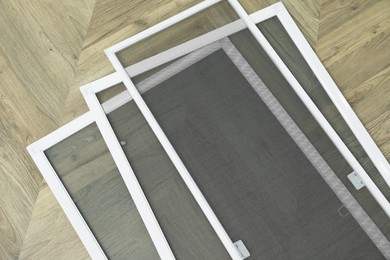 Set of window screens on wooden floor, flat lay