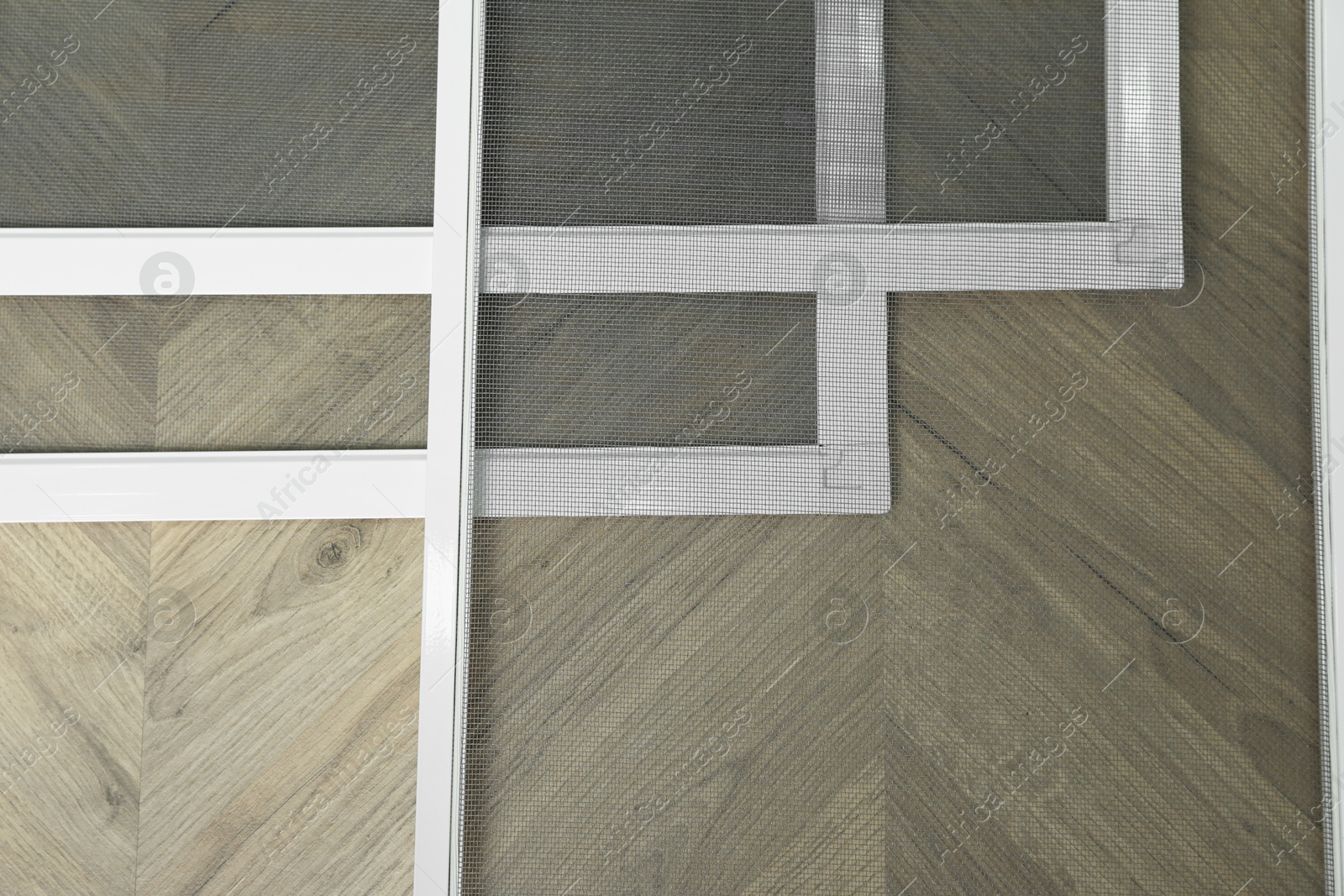 Photo of Set of window screens on wooden floor, flat lay