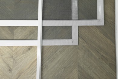 Set of window screens on wooden floor, flat lay