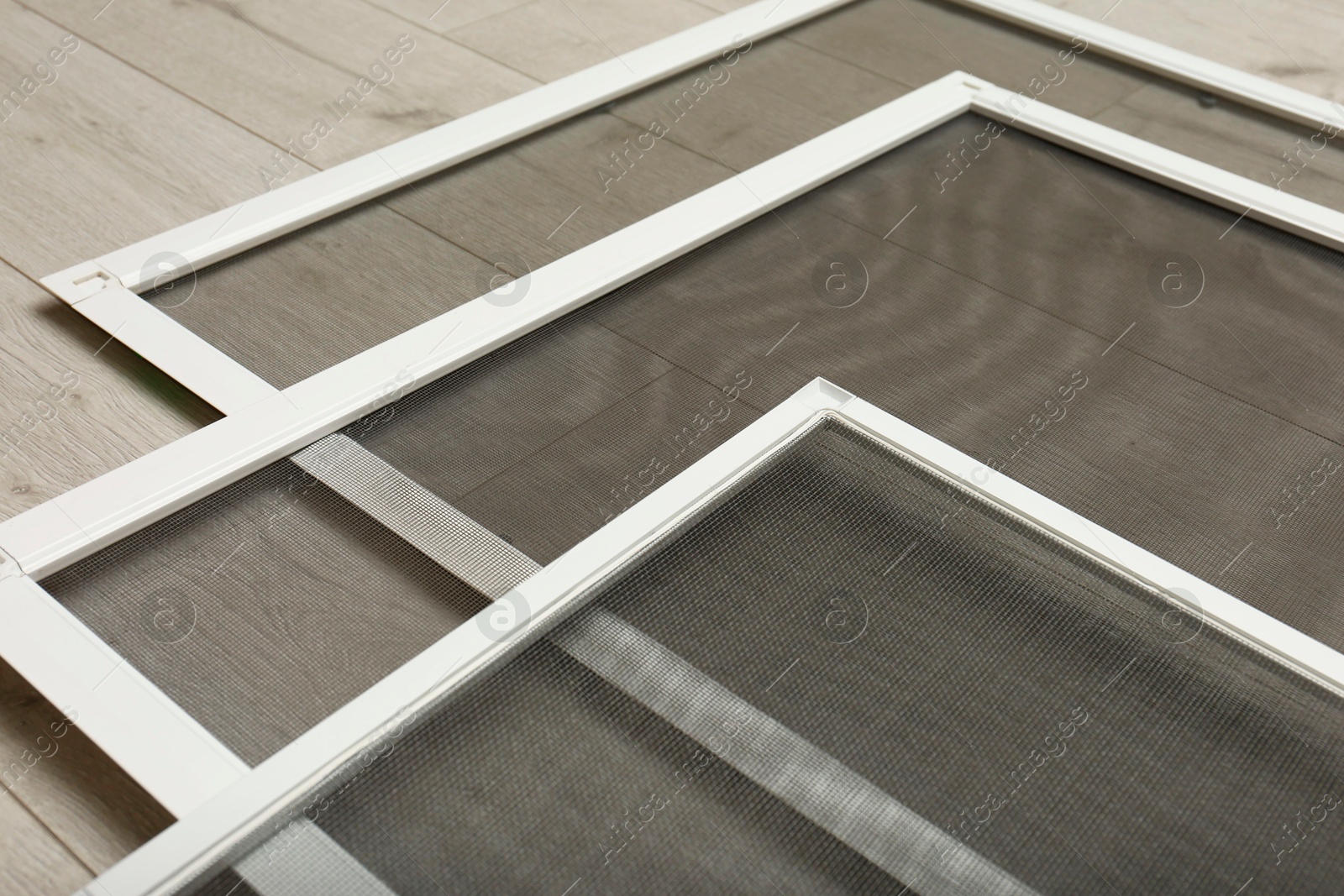 Photo of Set of window screens on wooden floor, closeup