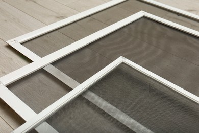 Set of window screens on wooden floor, closeup