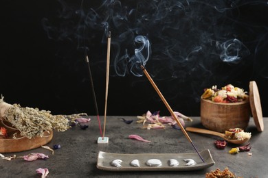 Photo of Aromatic incense sticks smoldering on grey table