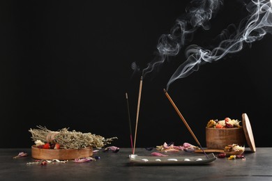 Aromatic incense sticks smoldering on grey table