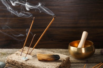 Photo of Aromatic incense sticks smoldering on wooden table