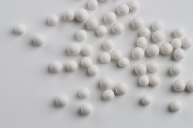 Photo of Homeopathic remedy. Many round pills on white background, flat lay