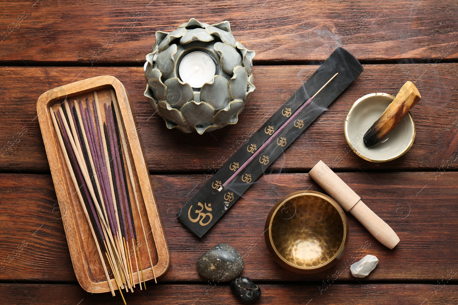 Photo of Flat lay composition with incense sticks on wooden table. Om ligature