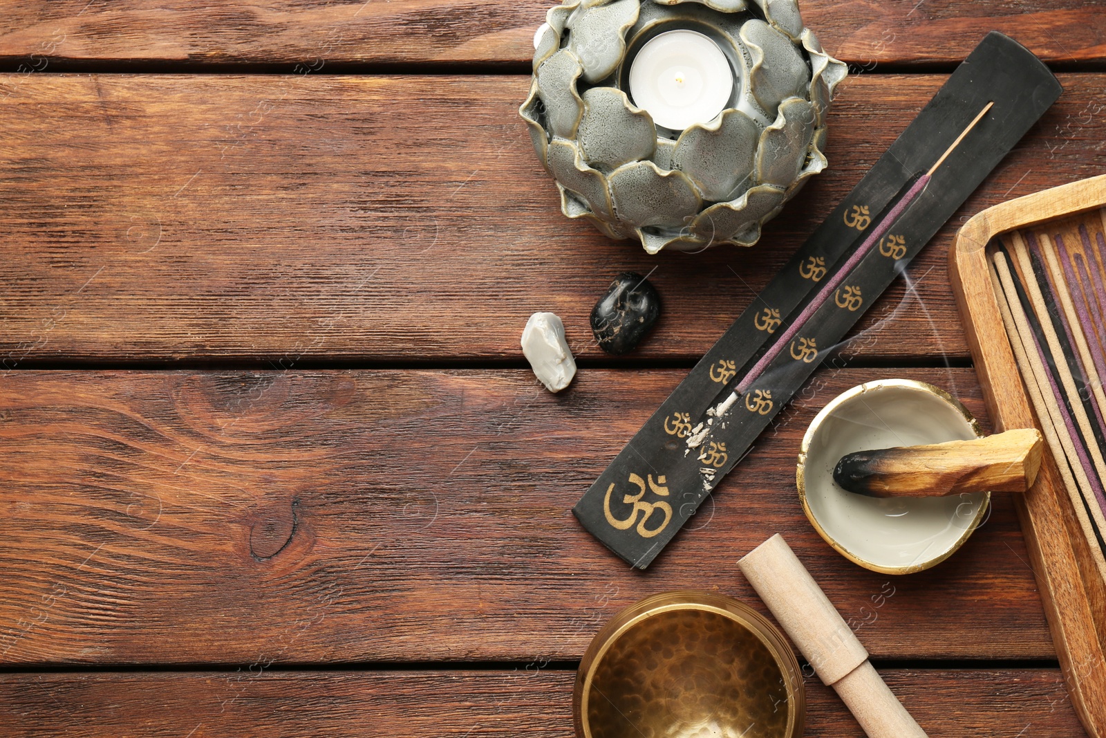 Photo of Flat lay composition with incense sticks on wooden table, space for text. Om ligature