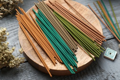 Incense sticks and dry flowers on gray wooden table