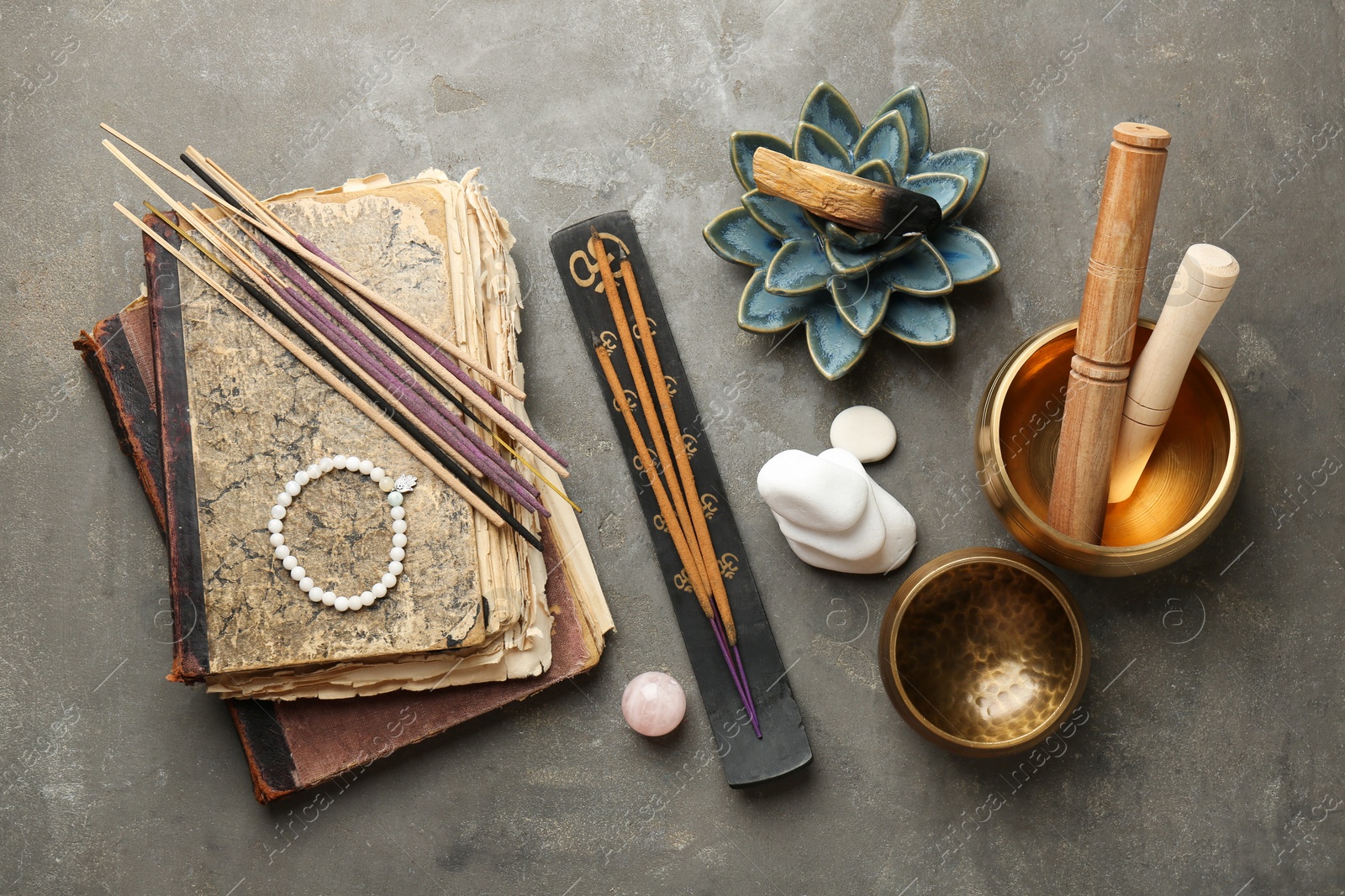 Photo of Flat lay composition with incense sticks on gray textured table. Om ligature