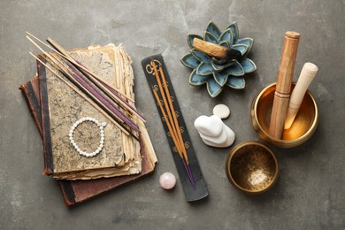 Flat lay composition with incense sticks on gray textured table. Om ligature