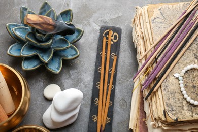 Flat lay composition with incense sticks on gray textured table. Om ligature