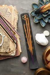 Photo of Flat lay composition with incense sticks on gray textured table. Om ligature