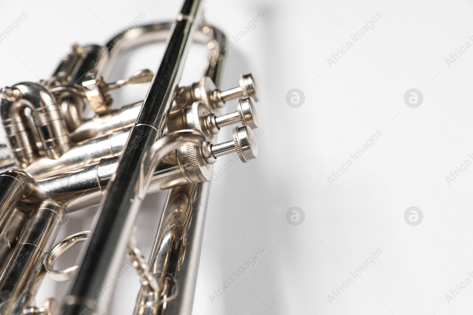 Photo of One trumpet on light background, closeup. Space for text