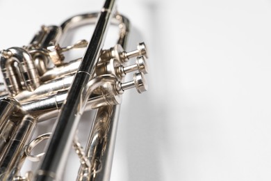 Photo of One trumpet on light background, closeup. Space for text