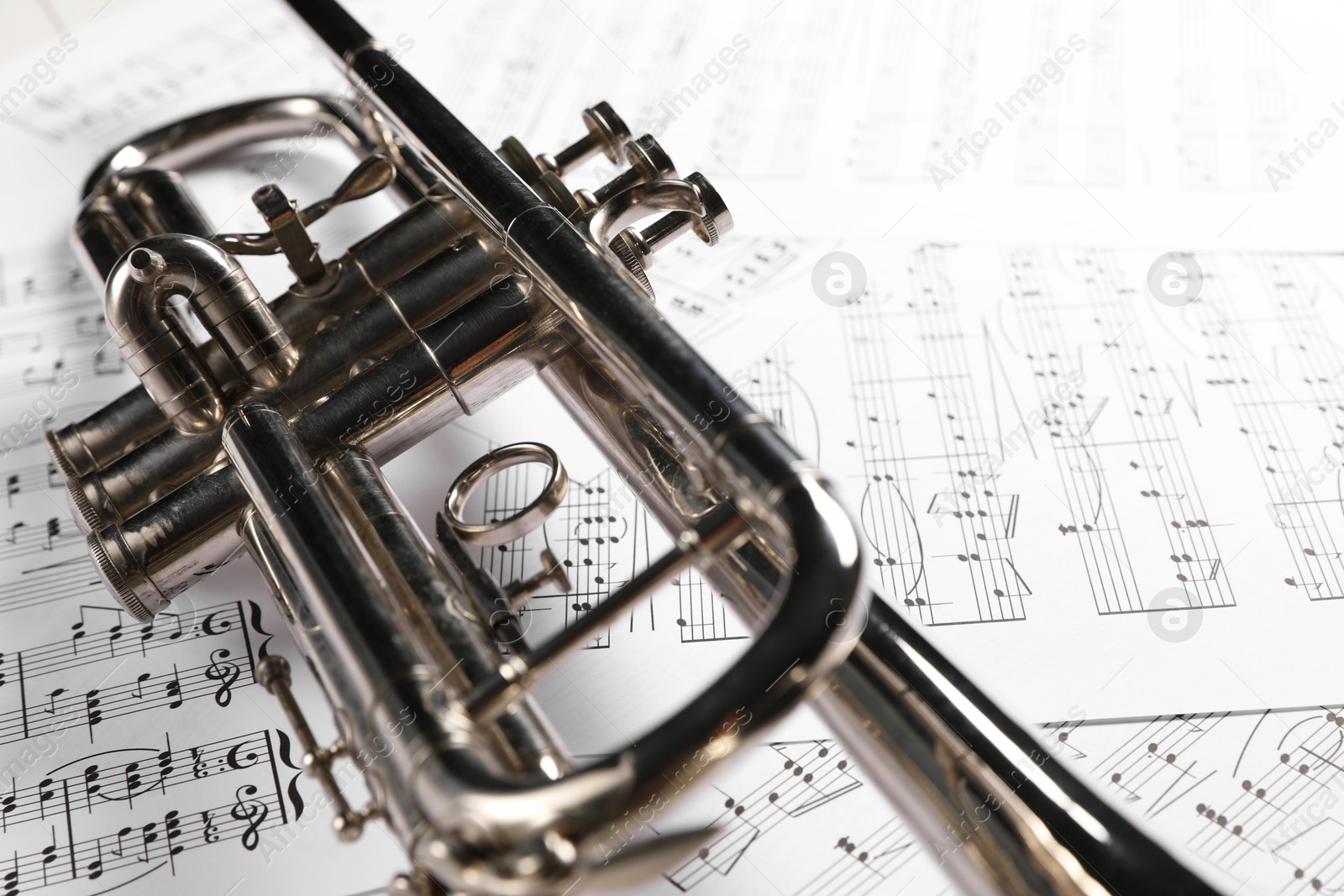 Photo of Trumpet on music sheet papers with notes, closeup