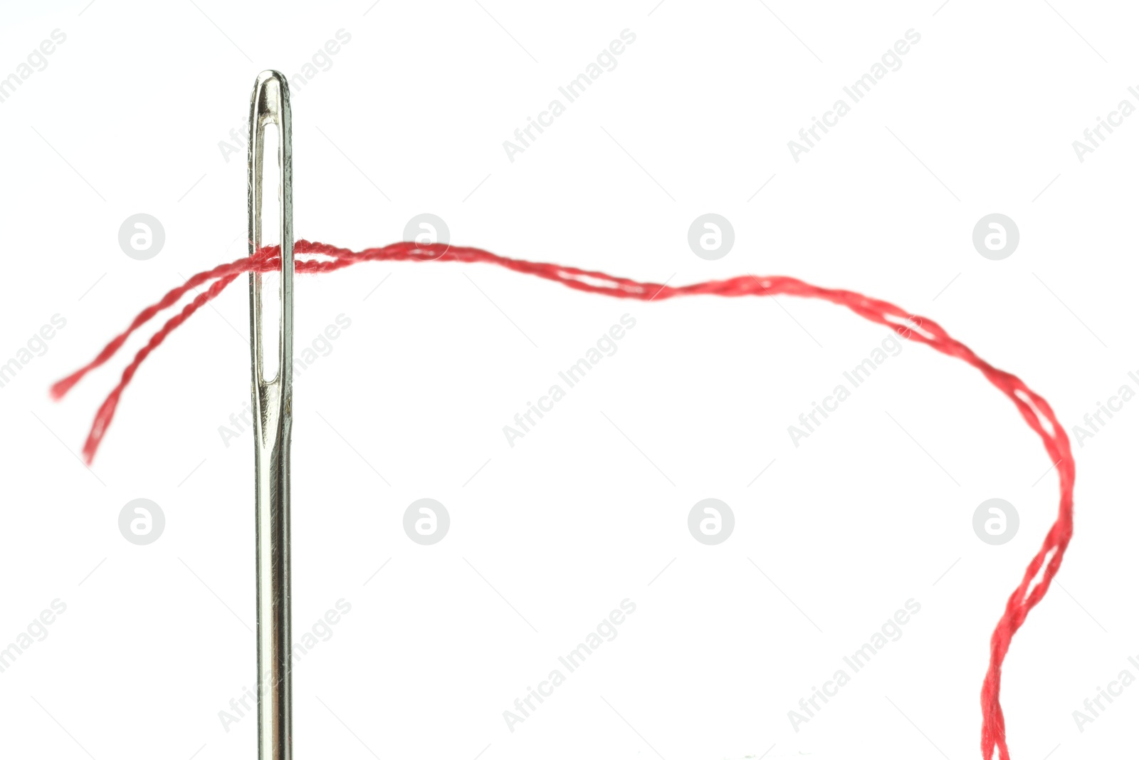 Photo of Sewing needle with red thread on white background, closeup