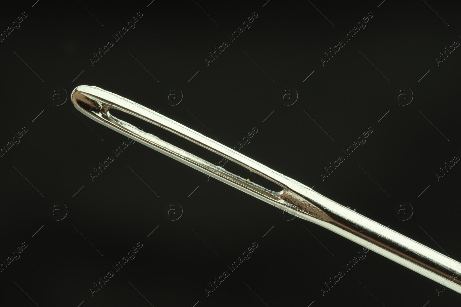 Photo of Sewing needle on black background, closeup view