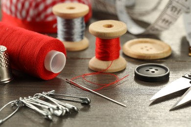 Photo of Different sewing tools on wooden table, closeup