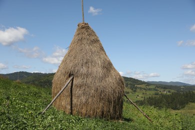 Photo of Pile of hay on field under blue sky