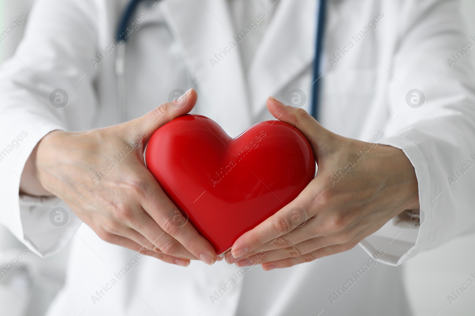 Photo of Doctor with red heart in clinic, closeup