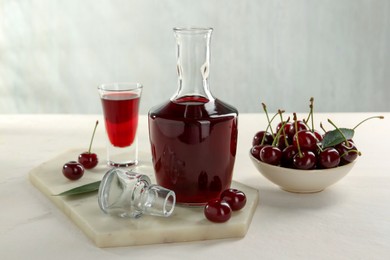 Photo of Delicious cherry liqueur and berries on white table